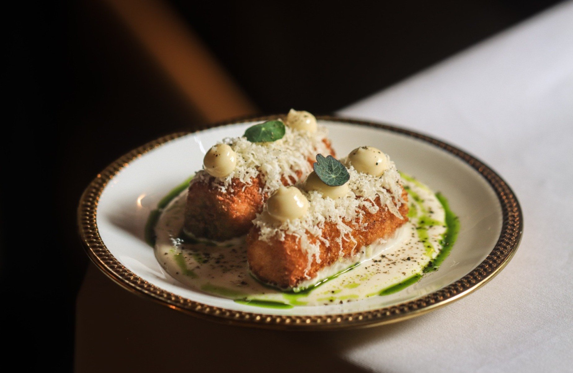 Croqueta de milho com fonduta de queijo e pimenta mo&iacute;da 