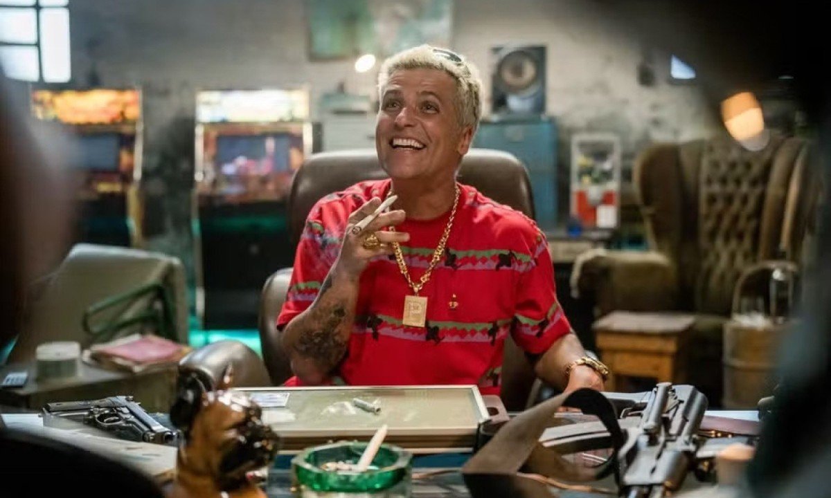 Com cabelos louros, Bruno Gagliasso est&aacute; sentado em mesa . Ele vive o bandido Playboy na s&eacute;rie Impuros 