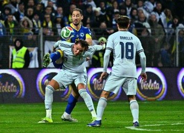 Nikola Katic (acima), da Bósnia, disputa a bola com o italiano Mateo Retegui, no jogo que marcou a classificação do time da Península Balcânica para o Mundial -  (crédito: Elvis BARUKCIC / AFP)