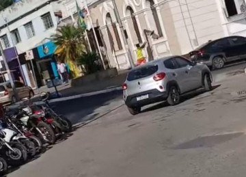 O suspeito, vestindo uma camisa da seleção brasileira, arremessa um objeto contra o vidro do prédio, que se estilhaça -  (crédito: Redes Sociais/Reprodução)