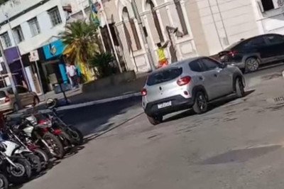 O suspeito, vestindo uma camisa da seleção brasileira, arremessa um objeto contra o vidro do prédio, que se estilhaça -  (crédito: Redes Sociais/Reprodução)