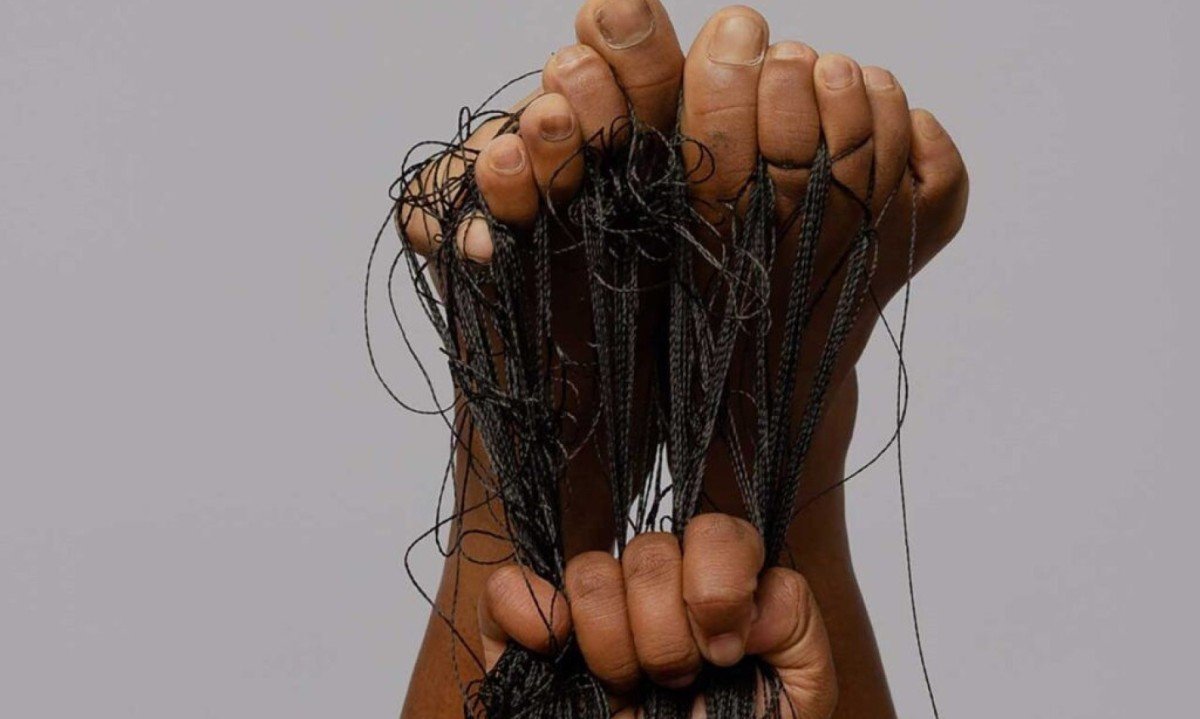 Fios pretos saem dos dedos dos p&eacute;s, virados para o alto, e s&atilde;o puxados por m&atilde;os em foto de divulga&ccedil;&atilde;o da exposi&ccedil;&atilde;o da artista Isabel Miranda na Funarte MG, em BH