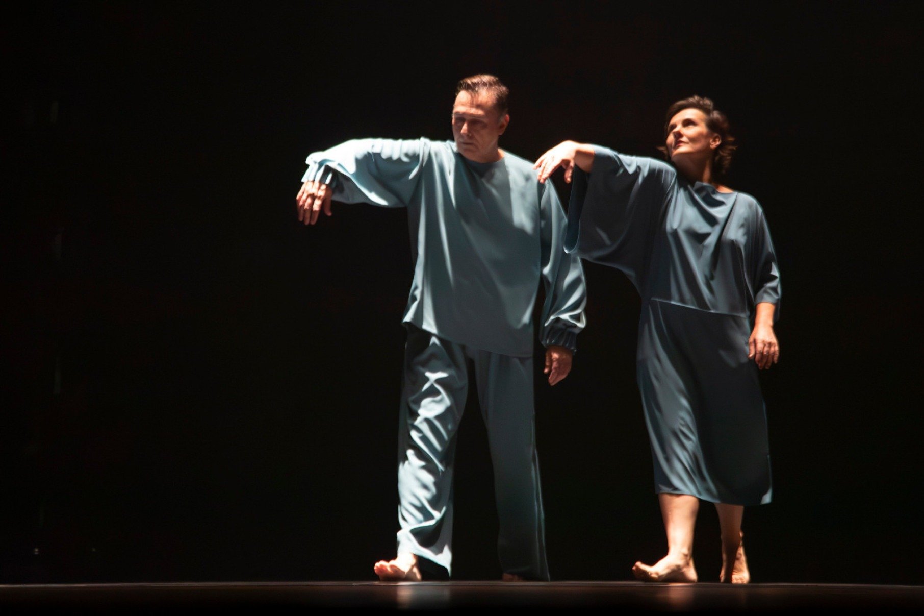Bailarino e bailarina do grupo mineiro Primeiro Ato est&atilde;o lado a lado, vestindo roupas azuis, durante apresenta&ccedil;&atilde;o da coreografia Como &aacute;gua