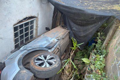 Carro caiu entre duas residências na rua Sabiá, no Bairro Adelmolândia, em Sabará -  (crédito: CBMMG)