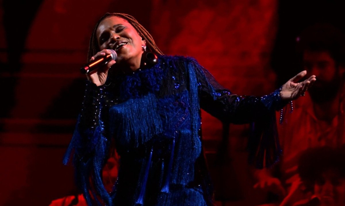 Teresa Cristina canta no palco de olhos fechados e segura o microfone