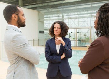  Business partners discussing project in office hallway. Focused serious business man and women talking to each other. Corporate meeting concept
     -  (crédito: Magnific/Freepik)
