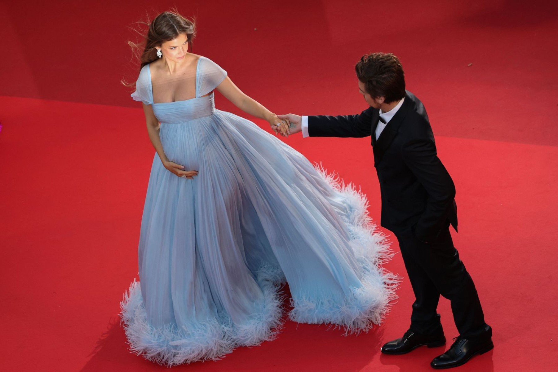 Modelo Barbara Palvin, com vestido azul rodado, e ator Dylan Sprouse assumem gravidez no tapete vermelho do 79ª Festival de Cannes