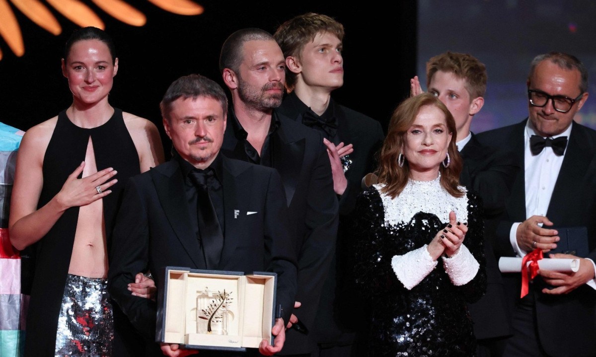 O diretor, roteirista e produtor romeno Cristian Mungiu posa no palco ao lado da atriz norueguesa Renate Reinsve, do ator romeno-americano Sebastian Stan e da atriz francesa Isabelle Huppert após ganhar a Palma de Ouro pelo filme 'Fjord' durante a cerimônia de encerramento da 79ª edição do Festival de Cinema de Cannes - (crédito: Sameer Al-Doumy/AFP)