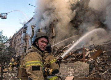 Bombeiros apagam incêndio em prédio atingido por bombardeio russo com mísseis a Kiev, capital da Ucrânia, na madrugada deste domingo (24/5)
 -  (crédito: Vladyslav Musienko/AFP)