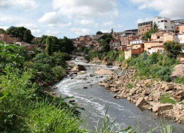 caldo cinzento -  as águas escuras do Ribeirão da Onça entre casas na Grande BH: curso é um dos afluentes do Rio das velhas que carregam mais poluentes para a bacia -  (crédito: Tanto Expresso/CBH Rio das Velhas/Divulgação)