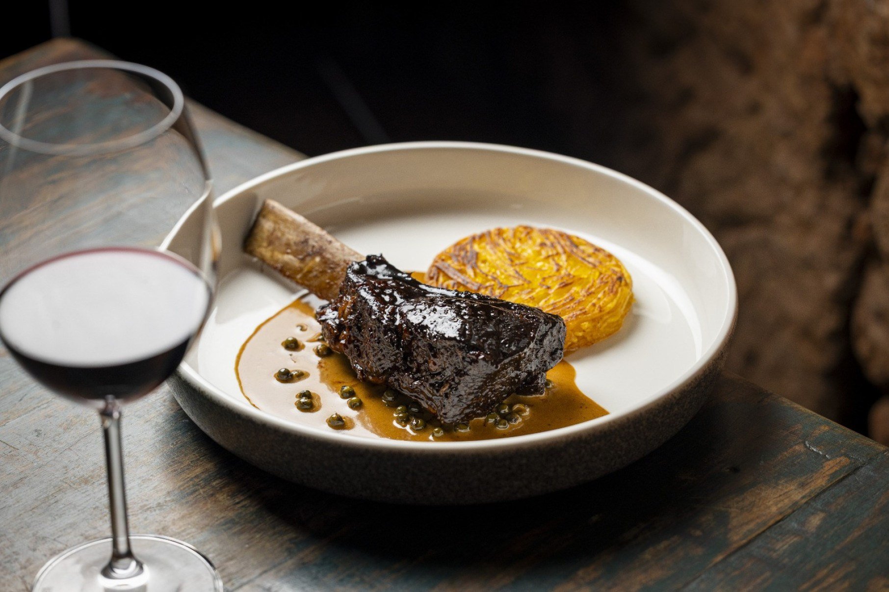 A costela bovina glaceada ganha sotaque franc&ecirc;s com o molho "au poivre" de pimenta e batata-baroa rosti 