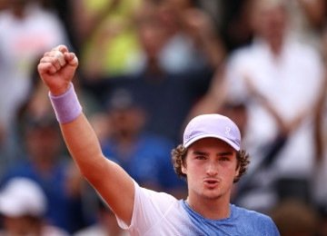 João Fonseca comemora a vitória sobre o francês Pierre-Hugues Herbert em Roland Garros  -  (crédito: Anne-Christine Poujoulat/AFP)