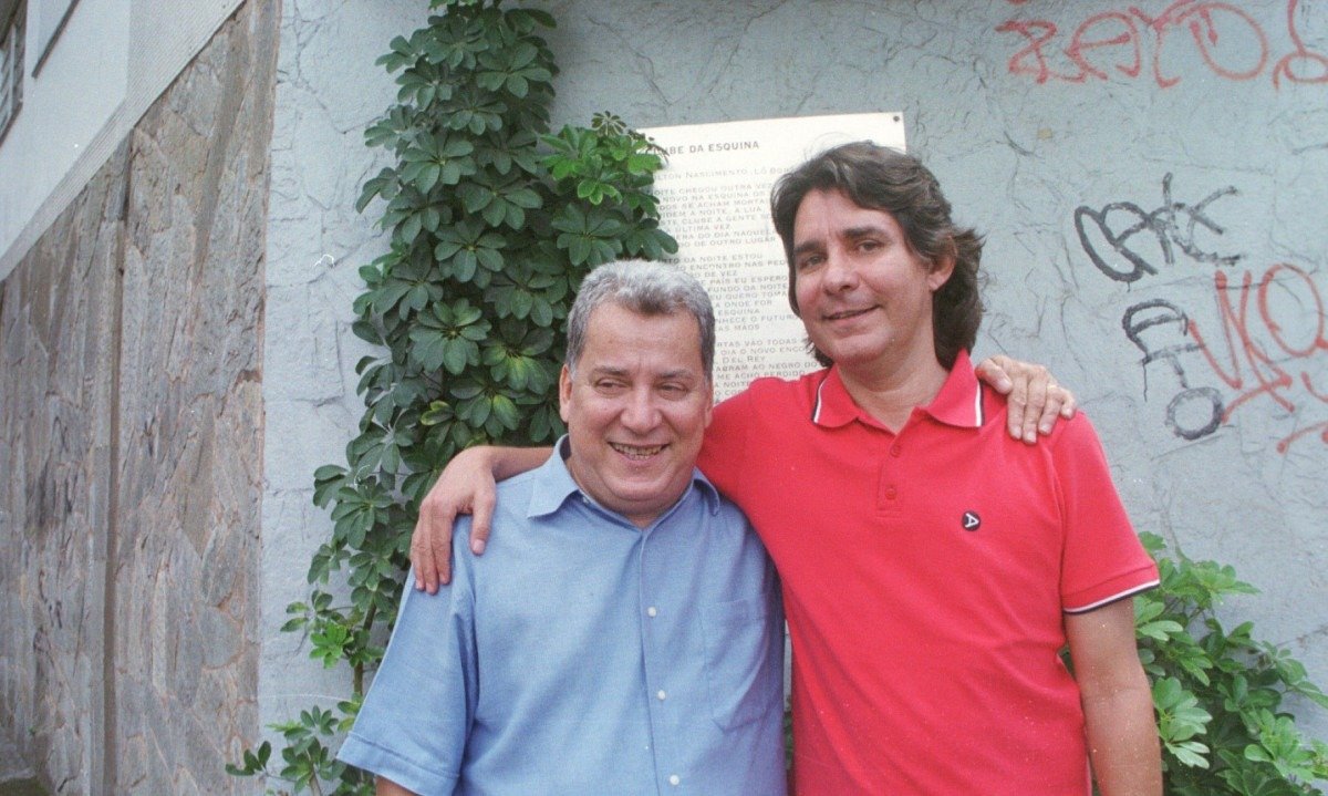  M&aacute;rcio Borges e L&ocirc; Borges abra&ccedil;ados em frente &agrave; placa que homenageia o Clube da Esquina, no Bairro Santa Tereza, em BH