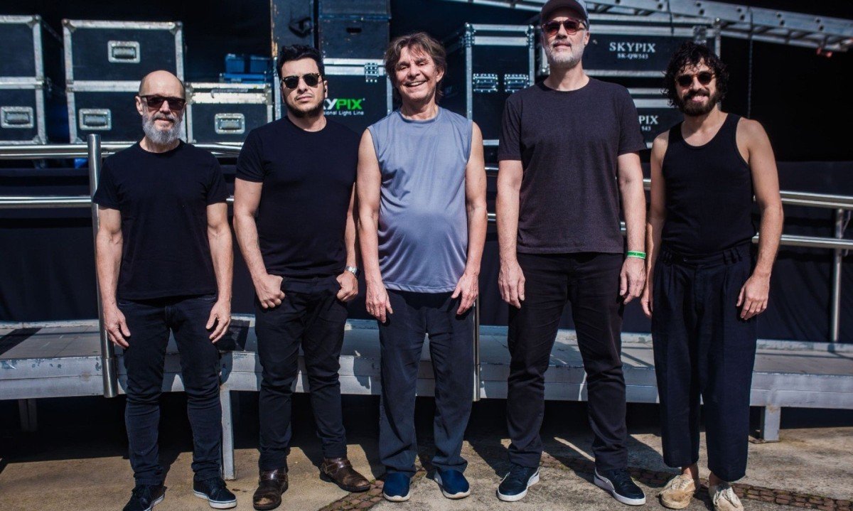  Baterista Robinson Matos, baixista Thiago Corr&ecirc;a, compositor L&ocirc; Borges, guitarrista Henrique Matheus e tecladista Felipe Dangelo est&atilde;o lado a lado e sorriem para a c&acirc;mera