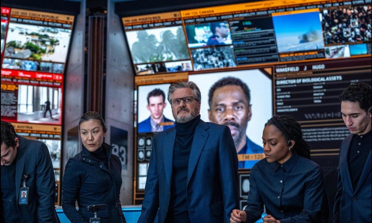 Ator Colin Firth est&aacute; em p&eacute; diante de mesa de controle no filme Dia D