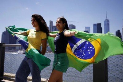 Torcedoras com a camisa e bandeira do Brasil na fan zone do Brooklyn, em Nova York: símbolos nacionais em disputa -  (crédito: Leonardo Munoz/AFP)