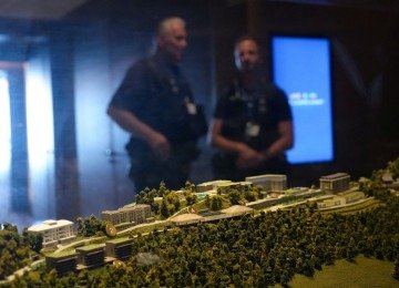 Policiais estão posicionados atrás de uma maquete do luxuoso hotel Burgenstock, exposta em uma vitrine no complexo hoteleiro Burgenstock, com vista para o Lago Lucerna, na Suíça, em 21 de junho de 2026, antes de negociações de alto nível destinadas a avançar em um acordo para pôr fim ao conflito no Oriente Médio. Uma nova rodada de negociações sobre a guerra no Oriente Médio estava marcada para começar em 21 de junho de 2026, com negociadores iranianos chegando à cidade suíça anfitriã horas antes do vice-presidente dos EUA, JD Vance, mesmo com Teerã anunciando o fechamento do Estreito de Ormuz novamente em resposta aos ataques israelenses no Líbano. (Photo by Nathan Howard / POOL / AFP)
       -  (crédito:  AFP)