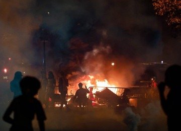 Torcedores do PSG se reúnem perto de uma barricada em uma rua próxima ao Arco do Triunfo após a vitória do clube na final da Liga dos Campeões da UEFA contra o Arsenal FC -  (crédito: Kenzo Tribouillard/AFP)