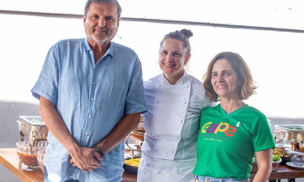 O presidente da entidade social Cape, Jos&eacute; Marc&iacute;lio, a chef Rachel Codreanschi e M&ocirc;nica Sales est&atilde;o lado a lado e sorriem para a c&acirc;mera durante feijoada beneficente em BH