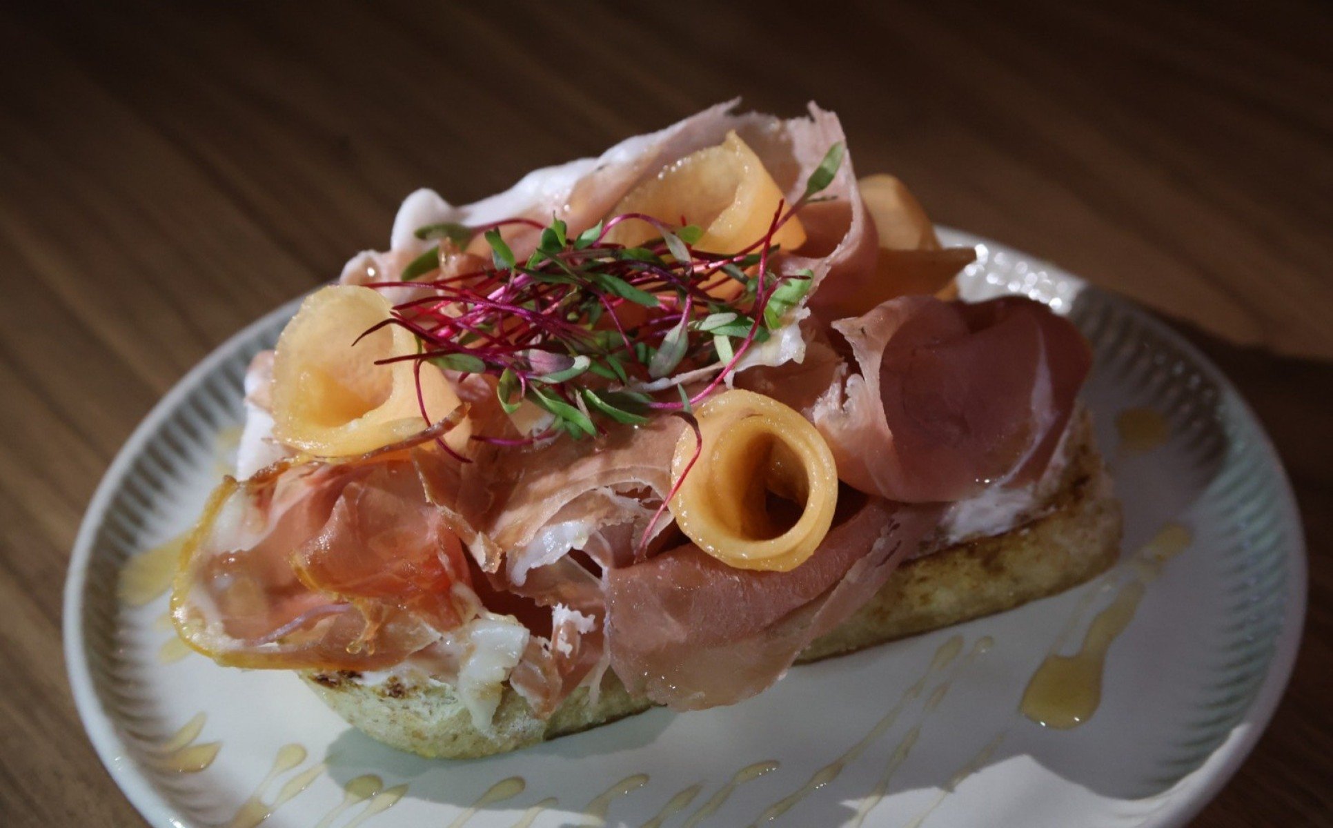 A tosta de parma com queijo boursin, mel&atilde;o e mel comp&otilde;e o menu do restaurante e da drinqueria 