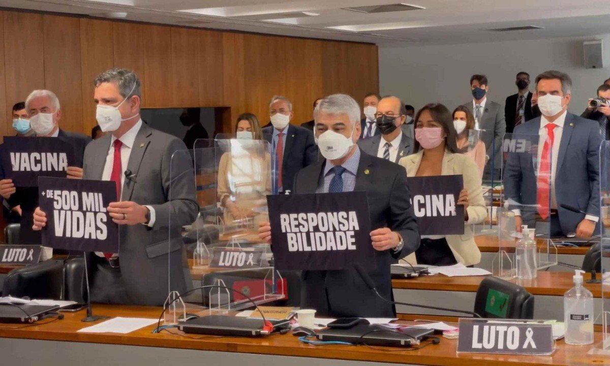  Durante a CPI da Covid, no Congresso, parlamentares seguram cartazes de fundo preto onde est&atilde;o escritas em letras brancas as palavras vacina, responsabilidade e luto, entre outras 
