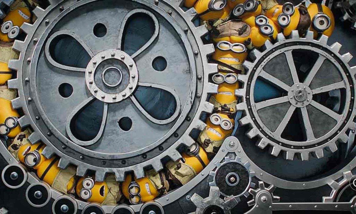 V&aacute;rios Minions amarelos est&atilde;o apertados dentro da engrenagem de m&aacute;quina de ferro em cena do filme Minions e os monstros 