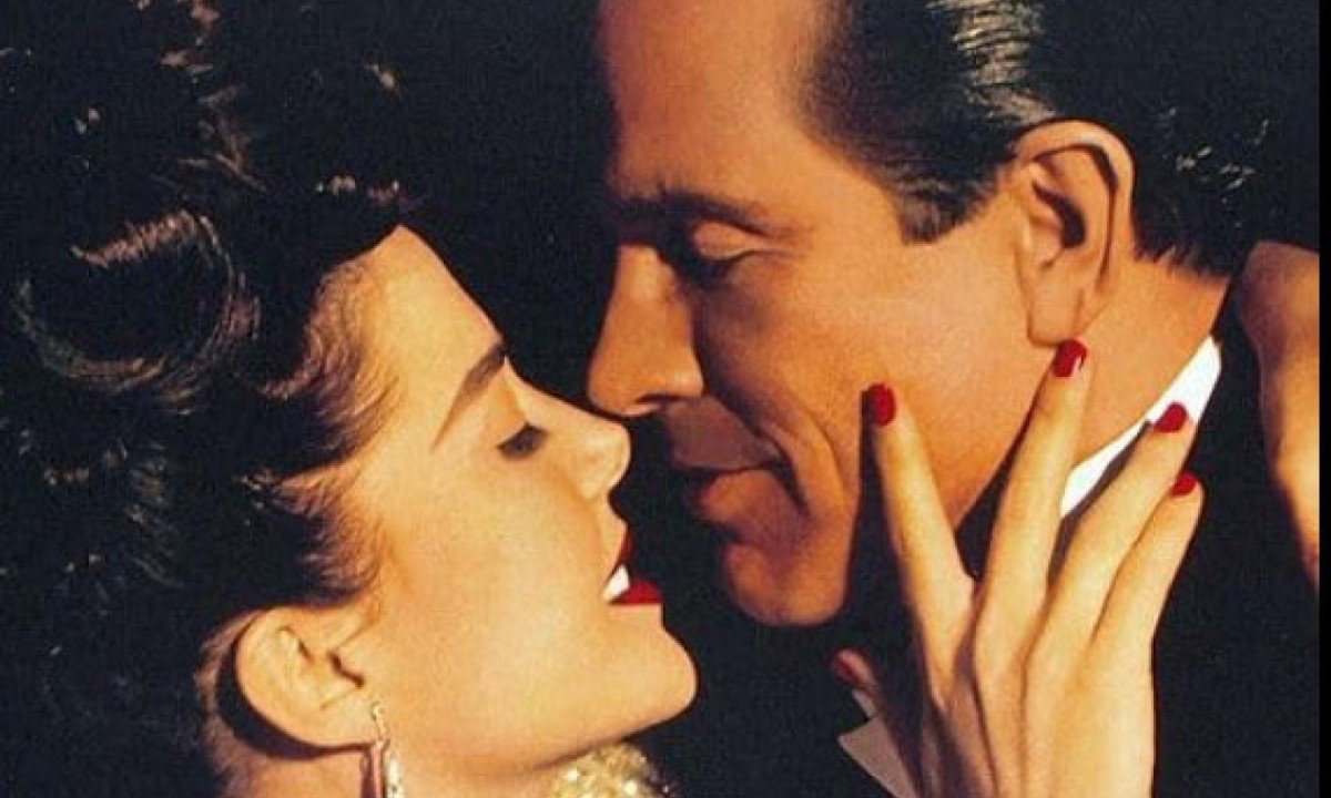 Atores Annette Bening e Warren Beatty est&atilde;o abra&ccedil;ados, quase se beijando, em cena do filme 'Bugsy'
