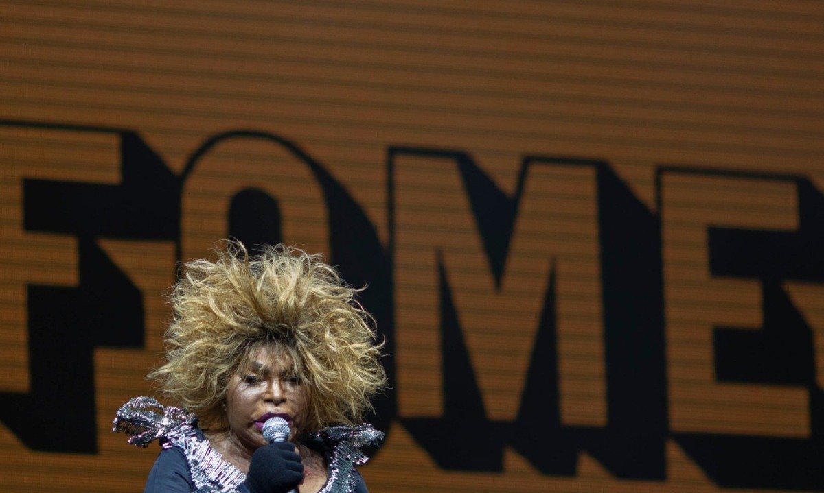A palavra fome est&aacute; escrita em letras garrafais atr&aacute;s da cantora Elza Soares durante show dela em 2019, no Rock in Rio