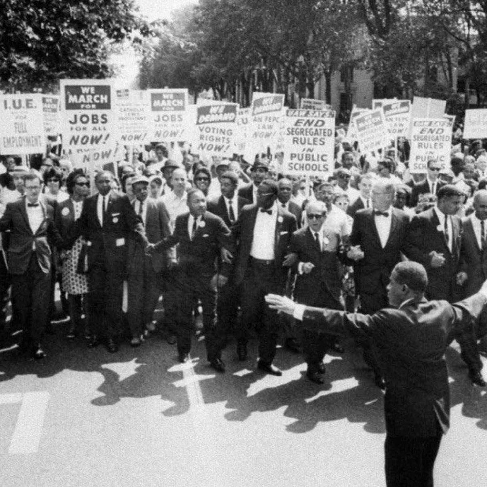 O l&iacute;der Negro Martin Luther King Jr. (ao centro) lidera a hist&oacute;rica Marcha sobre Washington  por Empregos e Liberdade, que reuniu cerca de 250 mil pessoas diante do Memorial Lincoln