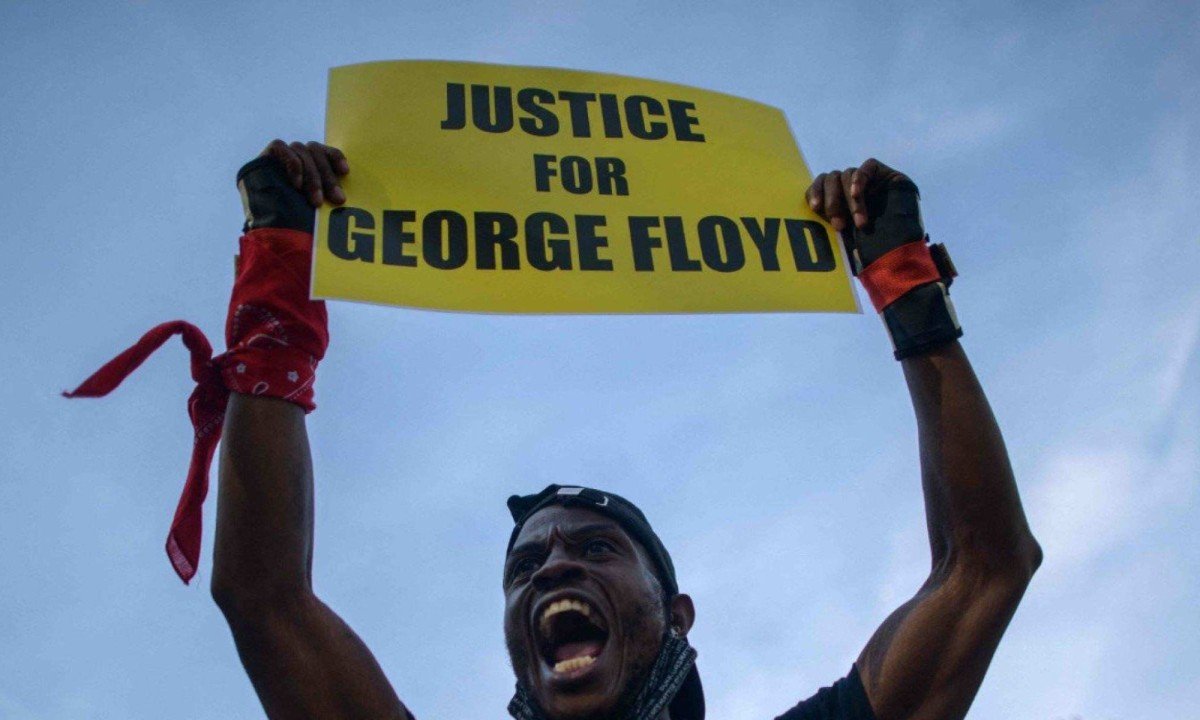 Manifestante do movimento Black Lives Matter (BLM) segura um cartaz e grita palavras de ordem durante uma marcha pelo anivers&aacute;rio da morte de George Floyd
