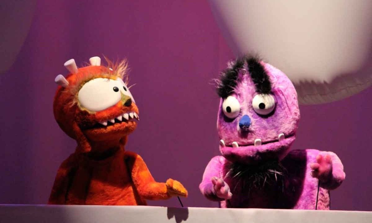 Dois bonecos cantam durante o show M&uacute;sica de brinquedo, da banda Pato Fu 