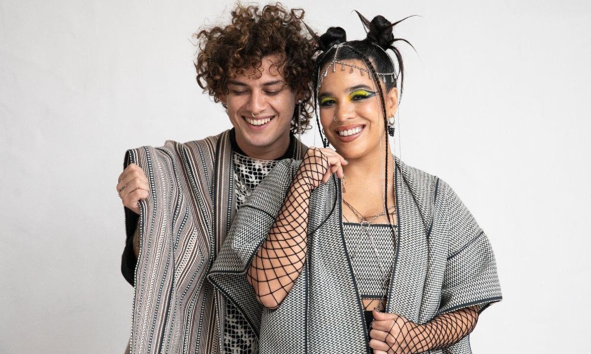 M&uacute;sicos Miguel Narv&aacute;ez e Jennifer Hicks est&atilde;o lado a lado e sorriem para a c&acirc;mera