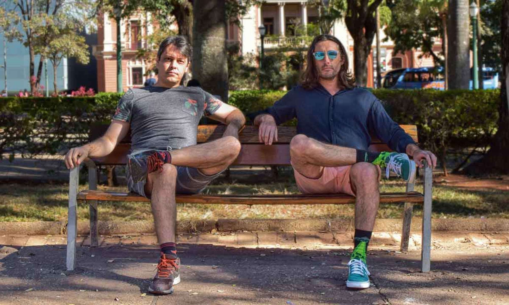Fotografia mostra os pianistas Evan Megaro e Marcelo Jiran sentados em banco na Pra&ccedil;a da Liberdade