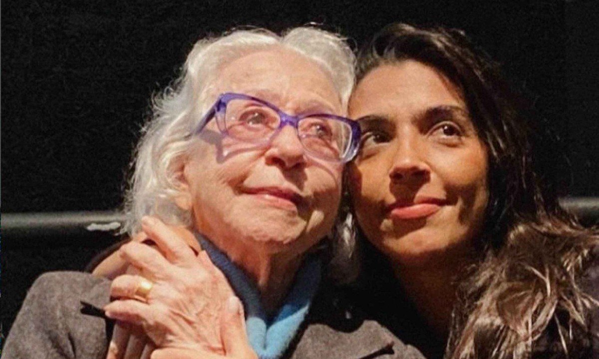Atriz Fernanda Montenegro &eacute; abra&ccedil;ada por Benedita Cas&eacute;. As duas est&atilde;o sentadas em plateia de teatro