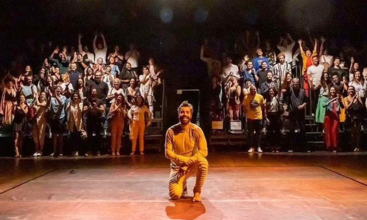  Ator Vandr&eacute; Silveira est&aacute; ajoelhado no palco e atr&aacute;s dele est&atilde;o espectadores, todos eles sorrindo para selfie, ap&oacute;s sess&atilde;o de A hora do boi no Rio de Janeiro
