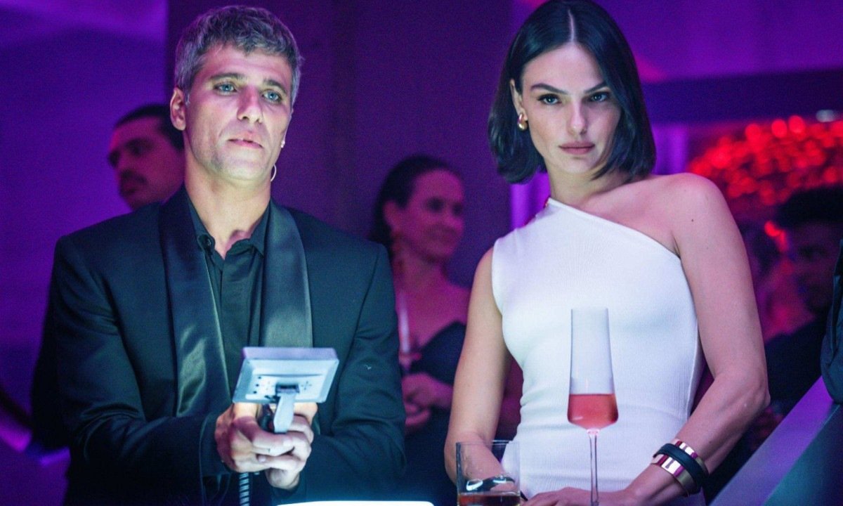 Os atores Bruno Gagliasso e Isis Valverde est&atilde;o lado a lado, &agrave; frente de microfone, em cena do filme Corrida dos bichos   