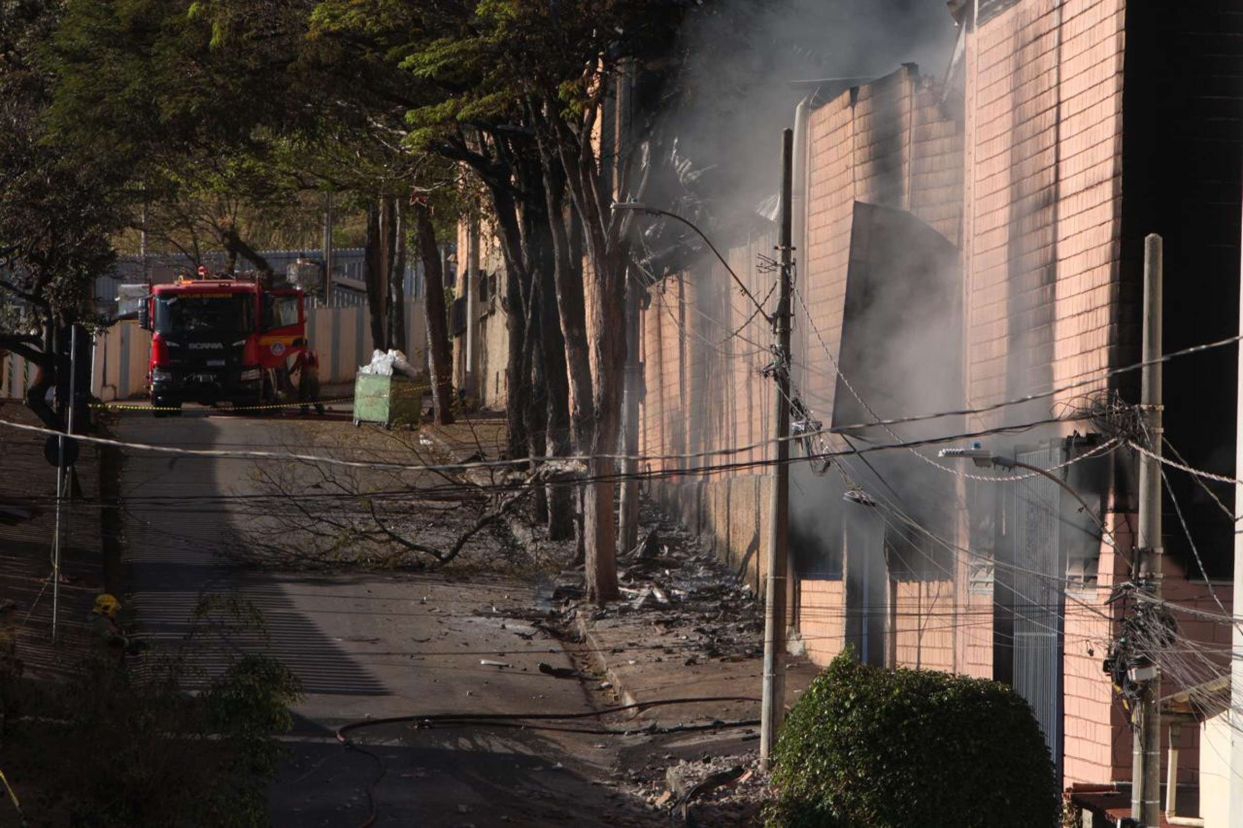 Destroços queimados estavam espalhados pela rua da fábrica
