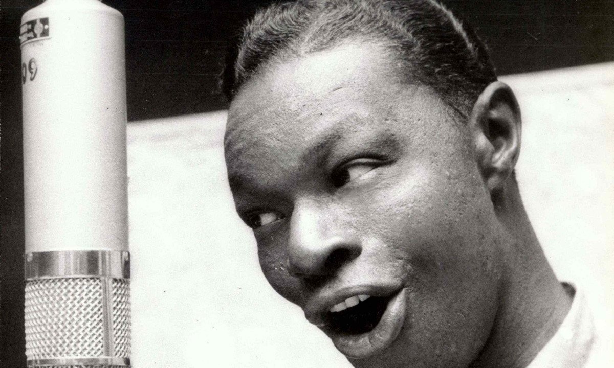 Nat King Cole canta em frente ao microfone