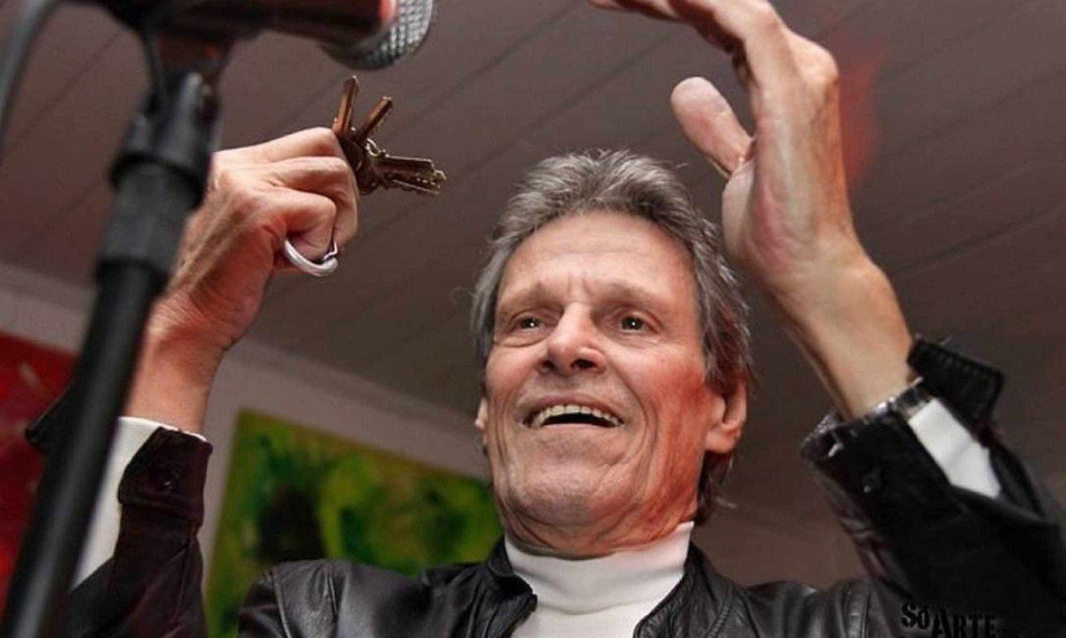 M&uacute;sico Orlandivo sorri e balan&ccedil;a chaves diante do microfone enquanto canta