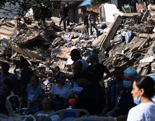 Pessoas buscam sobreviventes em meio aos escombros de um prédio que desabou após um terremoto em Cali, na Colômbia, em 10 de agosto de 2026       -  (crédito: JOAQUIN SARMIENTO / AFP)