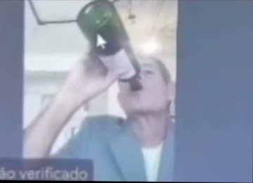 Milton Lívio Lemus Salles aparece de bermuda, fumando e bebendo de uma garrafa durante julgamento por videoconferência Tribunal de Justiça -  (crédito: Reprodução)