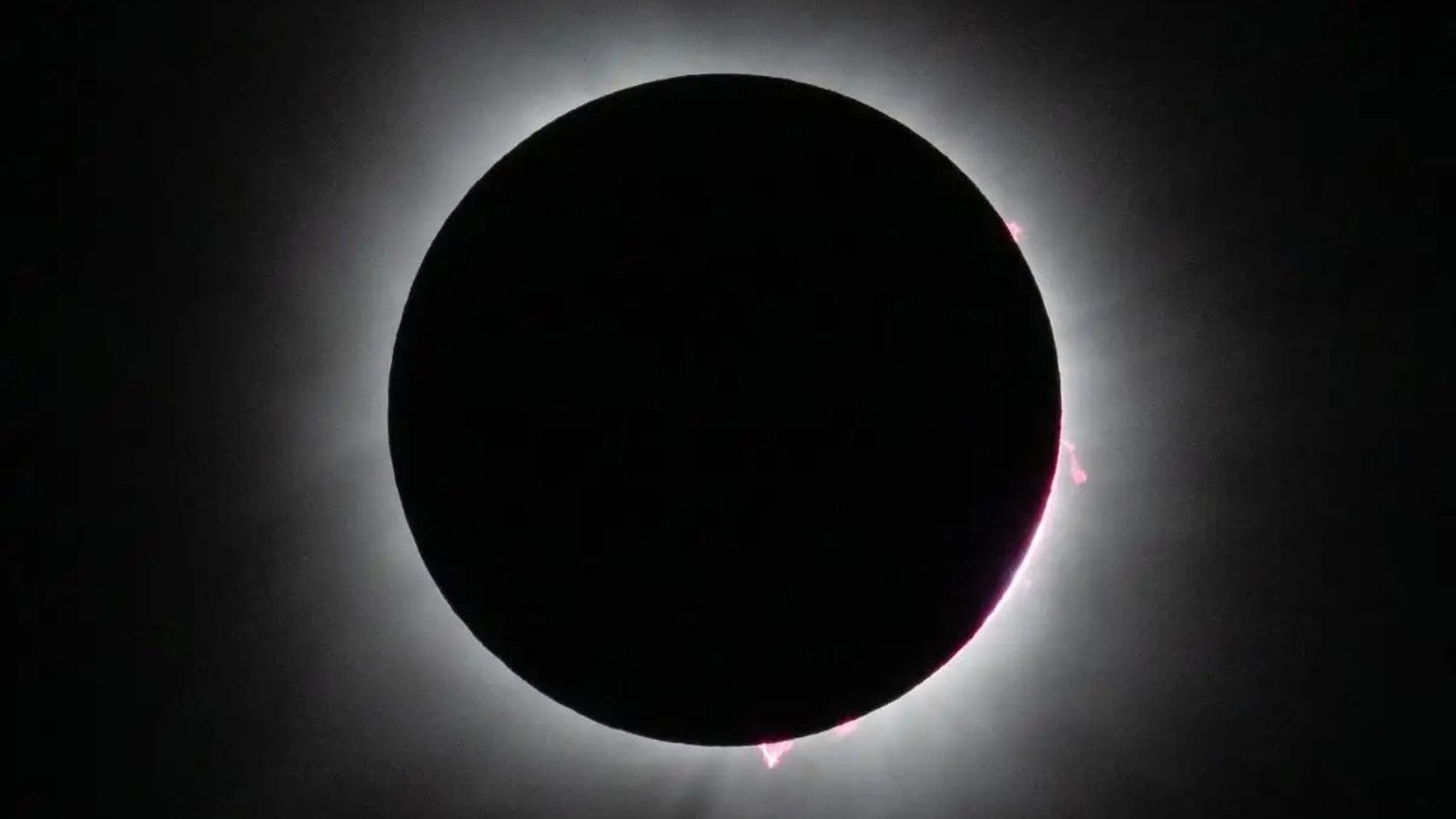 Um eclipse solar total, como o que ser&aacute; transmitido pela NASA, revela a coroa e proemin&ecirc;ncias solares -  (crédito:  NASA/Keegan Barber)