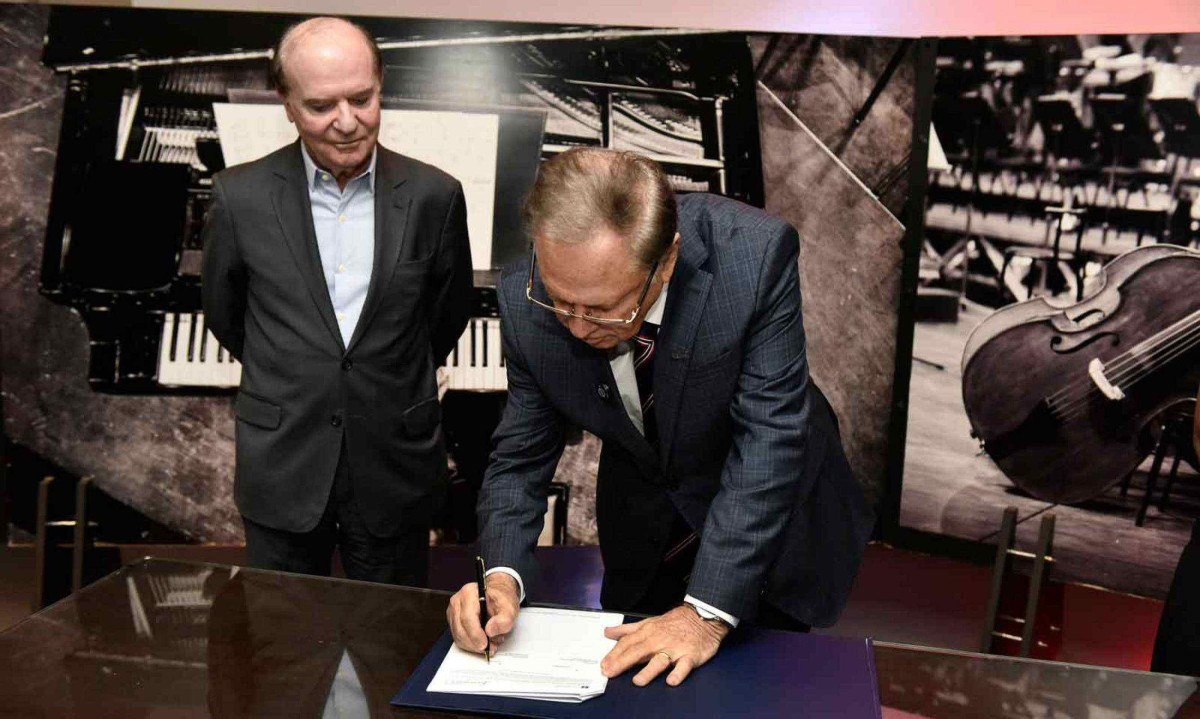 O presidente do Instituto Cultural Filarmônica, Wilson Brumer, e o presidente da ACMinas, Cledorvino Belini, assinam parceria entre as duas instituições, na Sala Minas Gerais -  (crédito: Fábio Ortolan/Divulgação)