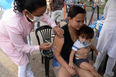 K&aacute;tia Ribeiro, 31, tomando vacina para Covid. No colo, seu filho Gael, de 1 ano e 1 m&ecirc;s, que j&aacute; estava com a vacina&ccedil;&atilde;o em dia -  (crédito: T&uacute;lio Santos/EM/D.A.Press)