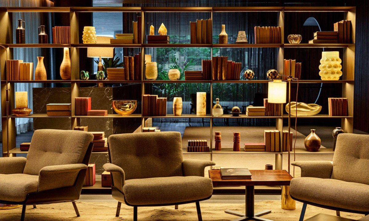 A estante do lobby &eacute; um espet&aacute;culo &agrave; parte: entre livros, objetos e design, ela traduz a eleg&acirc;ncia discreta do Fasano Itaim