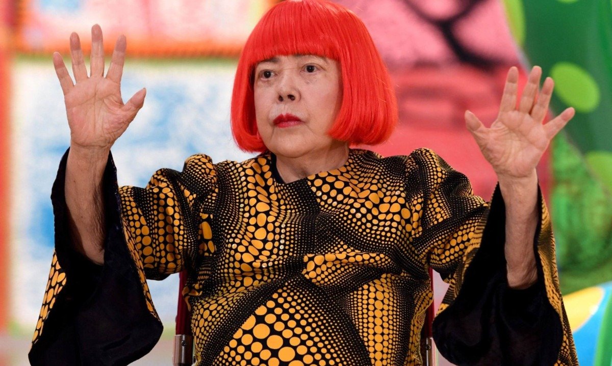 A artista japonesa Yayoi Kusama acena durante uma sessão de fotos na prévia para a imprensa de sua exposição "My Eternal Soul", no Centro Nacional de Arte, em Tóquio, em fevereiro de 2026. - (crédito: TOSHIFUMI KITAMURA/AFP)