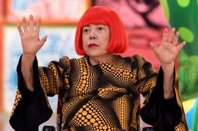 A artista japonesa Yayoi Kusama acena durante uma sessão de fotos na prévia para a imprensa de sua exposição 'My Eternal Soul', no Centro Nacional de Arte, em Tóquio, em fevereiro de 2026. -  (crédito: TOSHIFUMI KITAMURA/AFP)