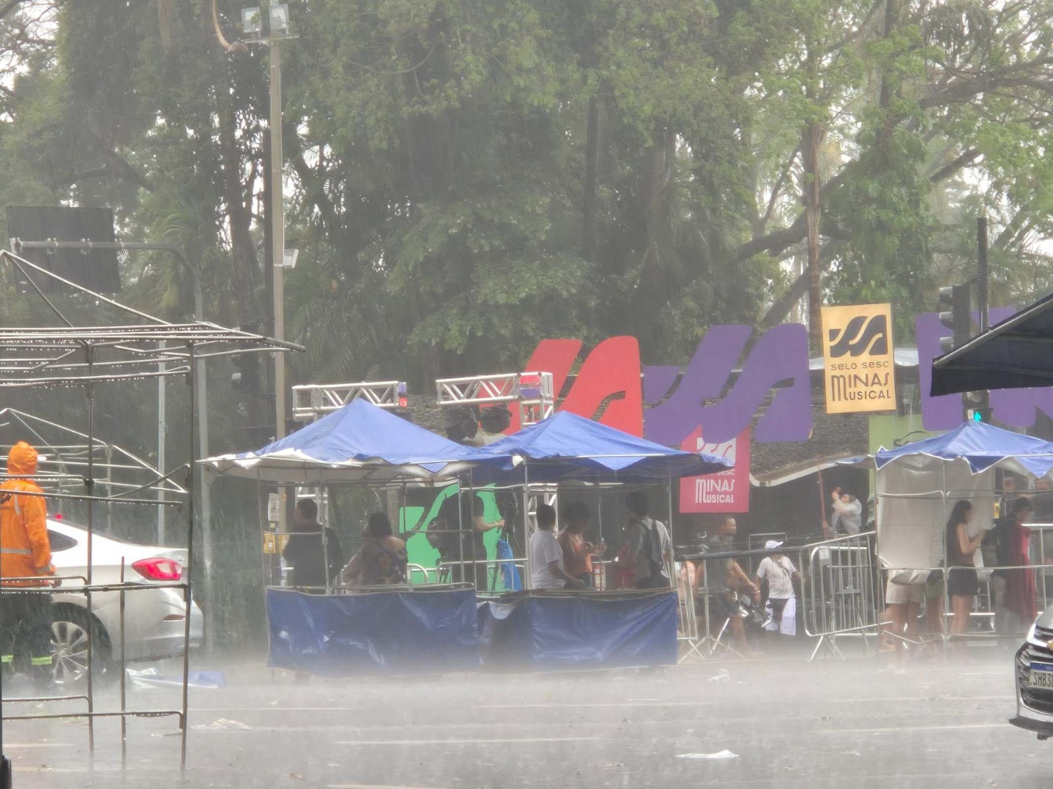 Pessoas buscaram abrigo sob uma barraca durante a chuva que atingiu BH neste domingo (30/08)