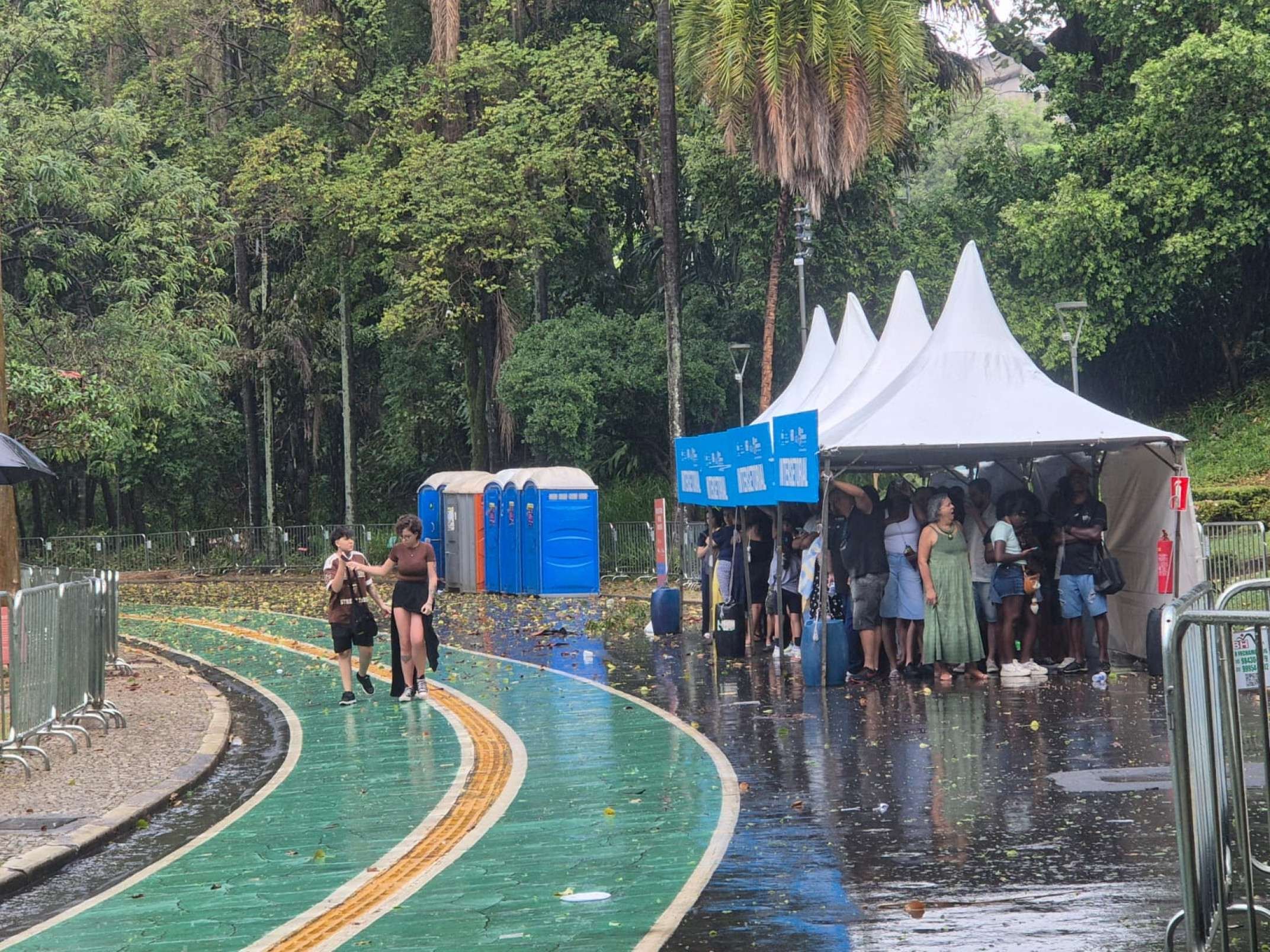 Pessoas buscaram abrigo sob uma barraca no Parque Municipal durante a chuva que atingiu BH neste domingo (30)08)