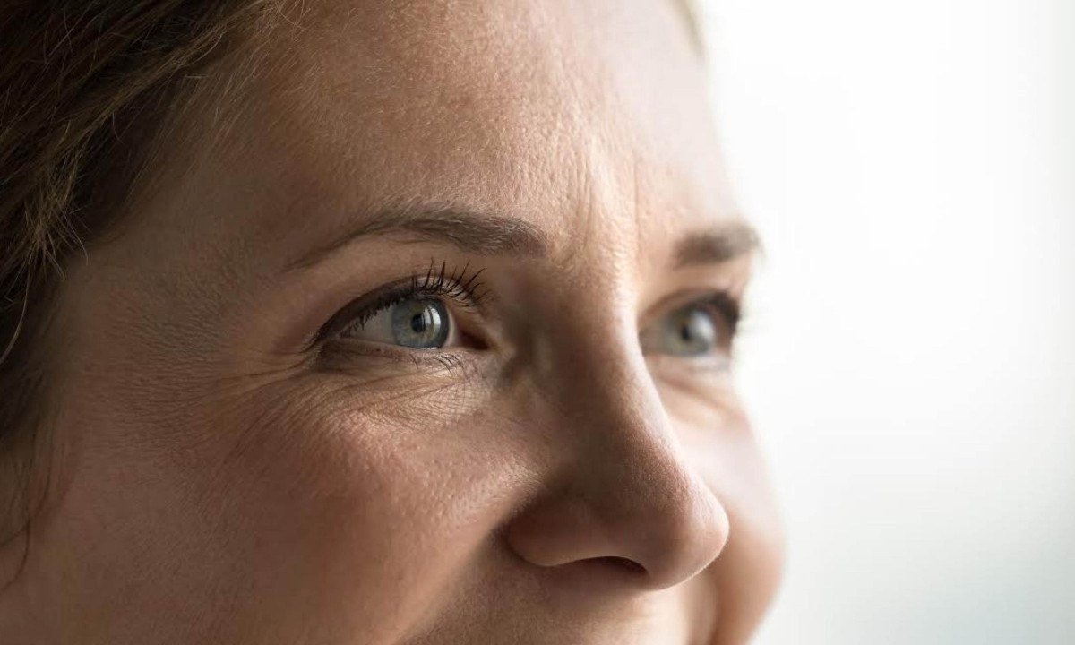 Blue eyes of young middle aged woman with black mascara on eyelashes looking away, smiling, laughing. Cropped shot banner. Female model upper face with natural makeup, dry facial skin with wrinkles
- (crédito: DINO)